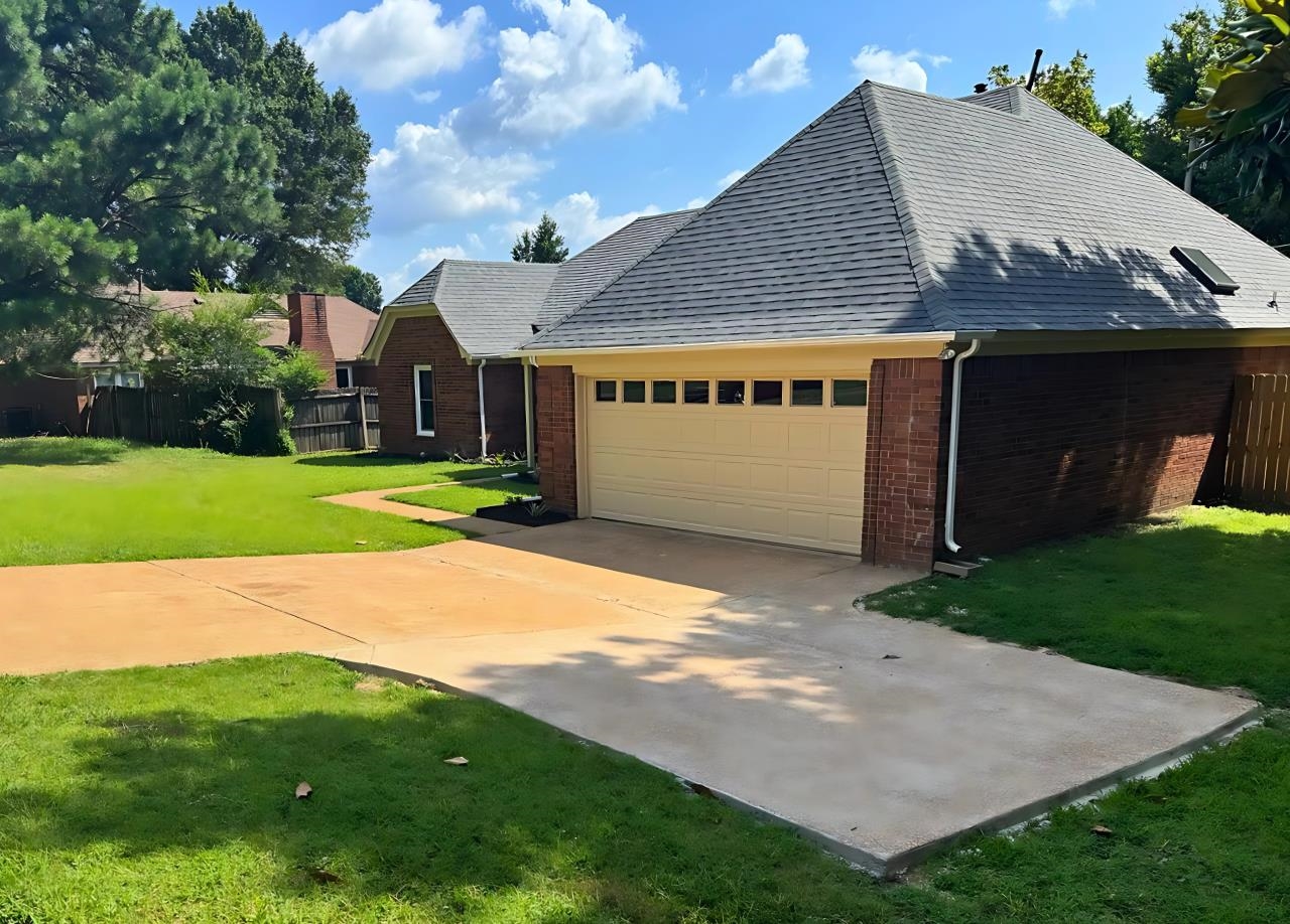 4386 South Germantown Road Memphis, TN 38125 - Photo 1 of 38 Front view features an attached garage, concrete driveway, and new turn-around pad for easier street access. Updates include epoxy garage floor and new gutters for added function and appeal.