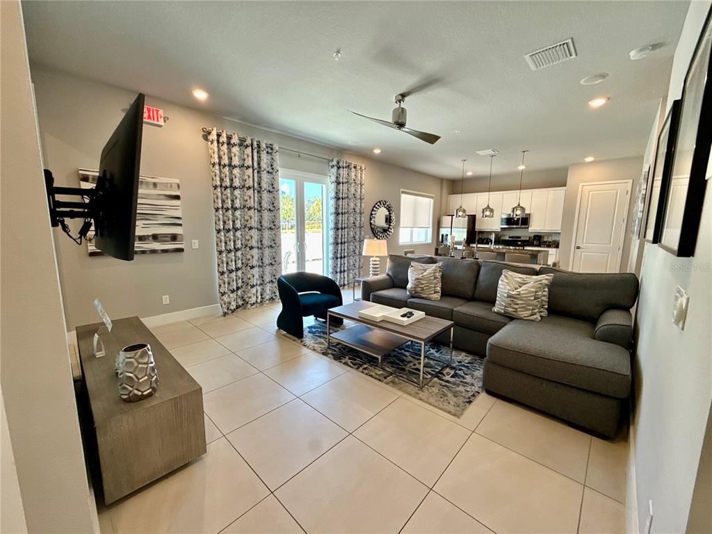 7740 Sandy Ridge Drive, Unit 120 Reunion, FL 34747 - Photo 3 of 36 a living room with furniture and a flat screen tv