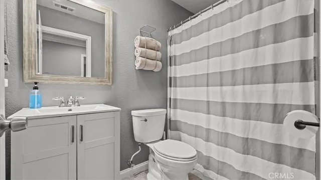 a bathroom with a sink a toilet and a mirror