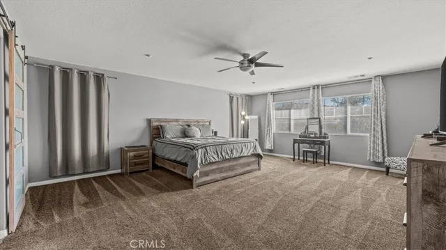 a spacious bedroom with a bed and a chandelier
