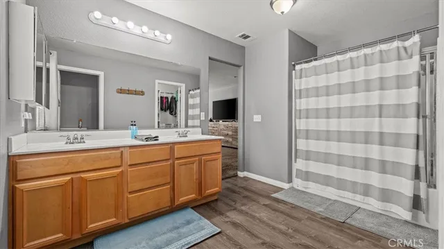 a bathroom with a double vanity sink mirror and shower