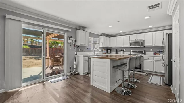 a kitchen with a table chairs refrigerator and cabinets