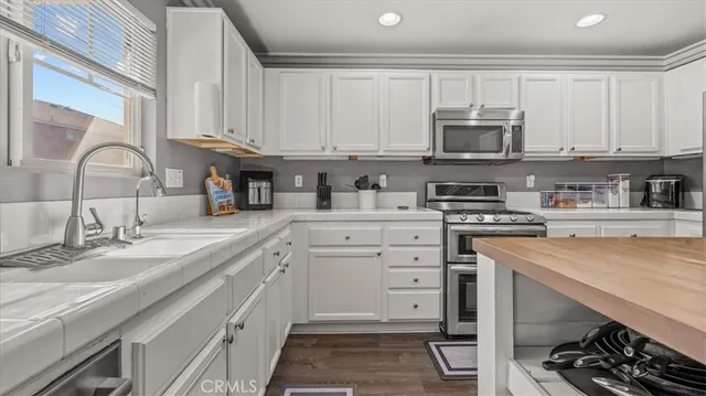 a kitchen with stainless steel appliances granite countertop a sink and a stove