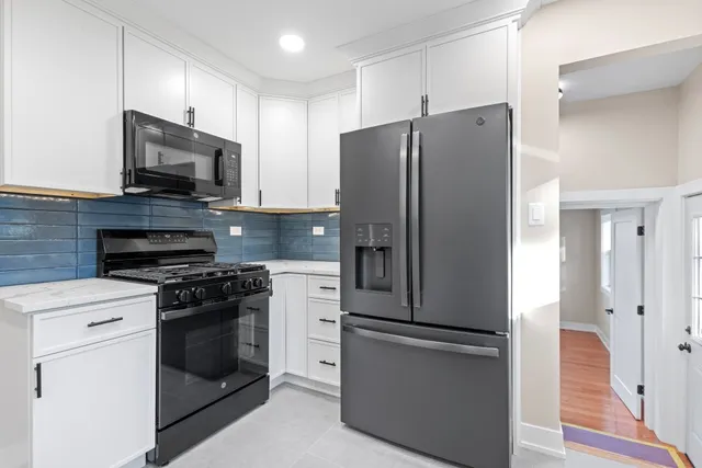 a kitchen with granite countertop white cabinets and sink