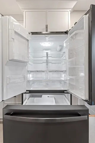 a kitchen with stainless steel appliances white cabinets and a stove a refrigerator with wooden floor