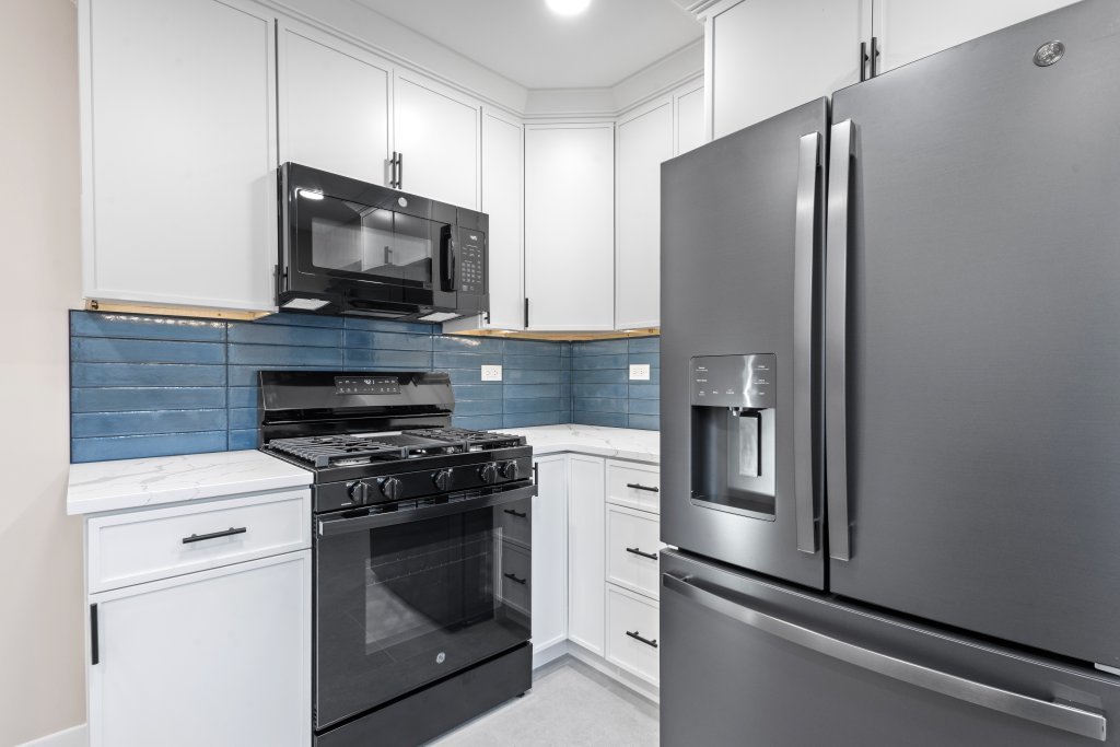 1619 North 20th Avenue Melrose Park, IL 60160 - Photo 19 of 40 a kitchen with stainless steel appliances white cabinets and a stove a refrigerator with wooden floor