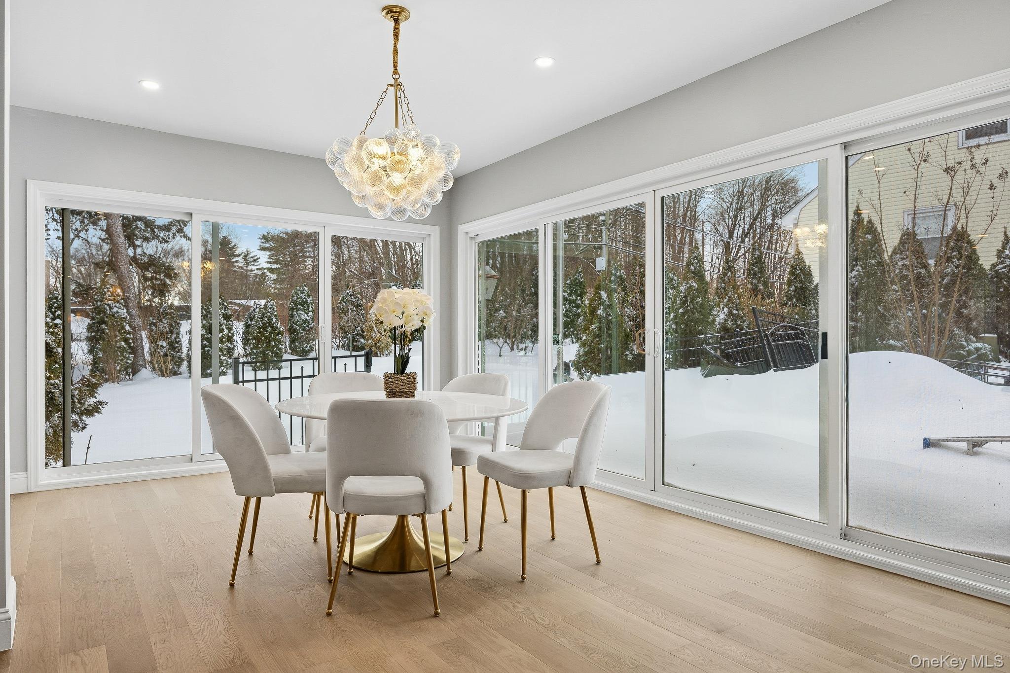 2 Wynmor Road Scarsdale, NY 10583 - Photo 6 of 38 a dining room with furniture large windows and a chandelier