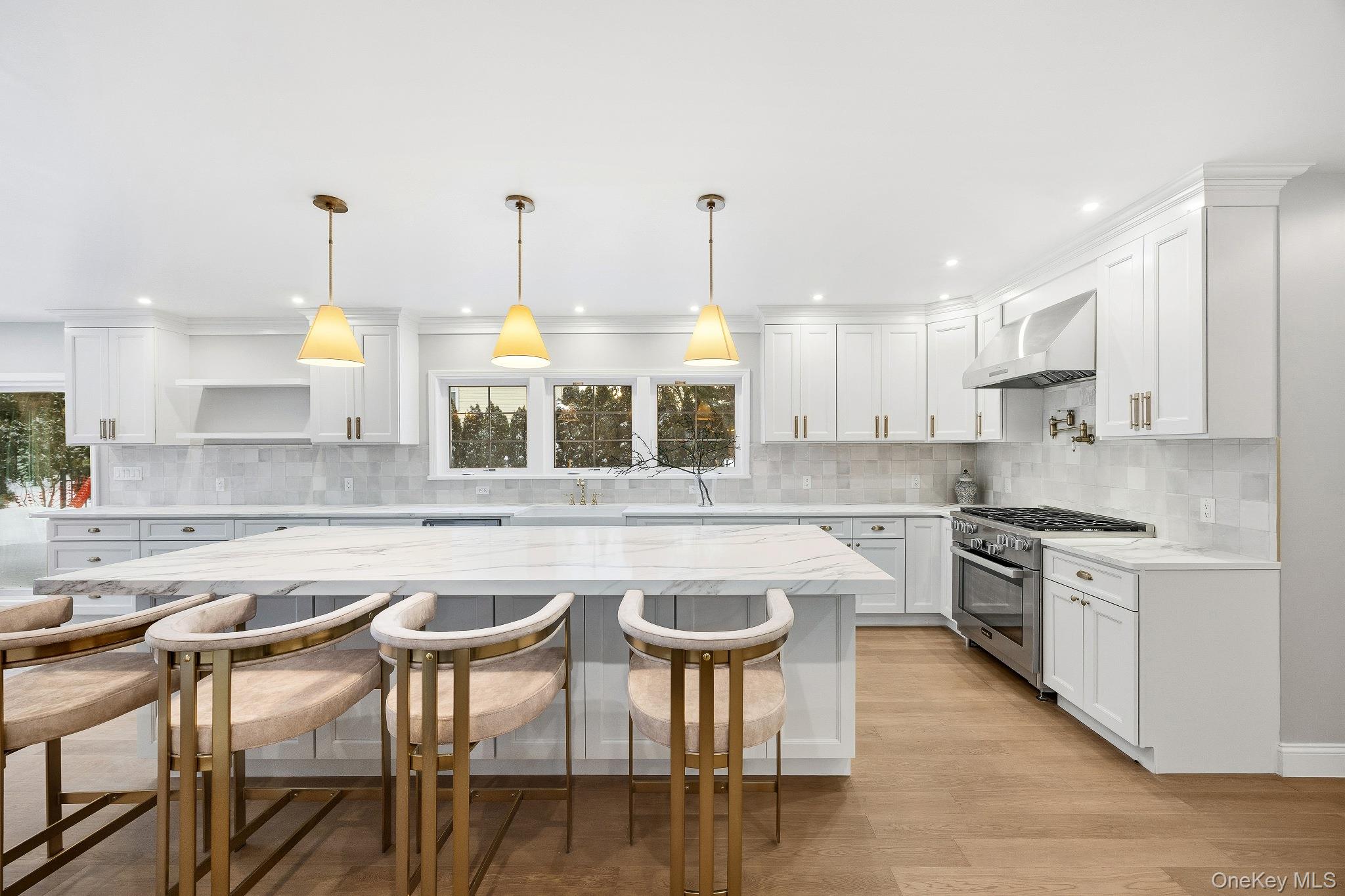 2 Wynmor Road Scarsdale, NY 10583 - Photo 9 of 38 a kitchen with stainless steel appliances granite countertop a stove top oven a sink a dining table and chairs with wooden floor
