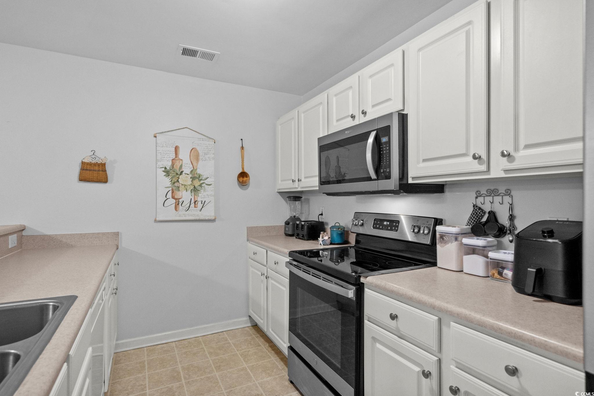 4849 Meadowsweet Drive, Unit 1606 Myrtle Beach, SC 29579 - Photo 12 of 36 Kitchen featuring appliances with stainless steel finishes, white cabinets, and light countertops