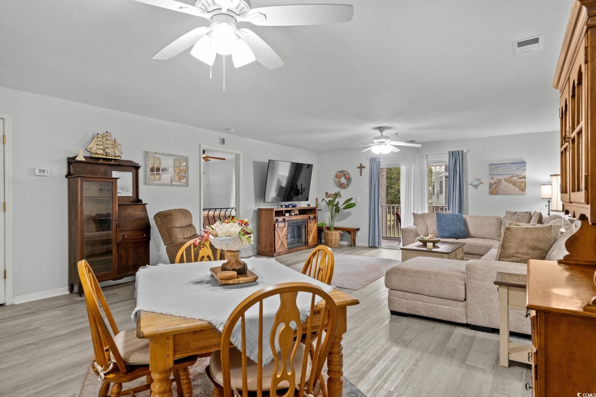 4849 Meadowsweet Drive, Unit 1606 Myrtle Beach, SC 29579 - Photo 10 of 36 Dining space with light wood-type flooring and a glass covered fireplace