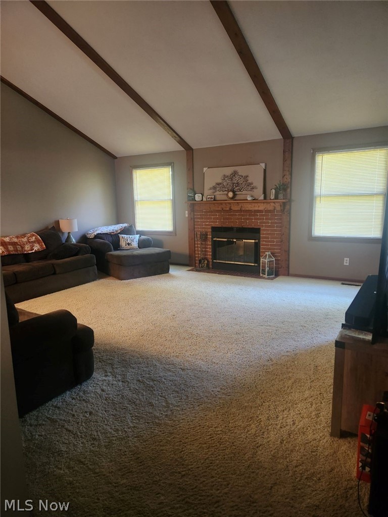 1166 Bass Circle Northwest Canton, OH 44708 - Photo 8 of 25 Carpeted living room featuring lofted ceiling with beams and a fireplace