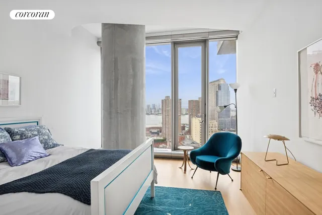 a living room with furniture a flat screen tv and a floor to ceiling window
