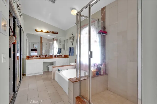 a bathroom with a tub shower sink and mirror