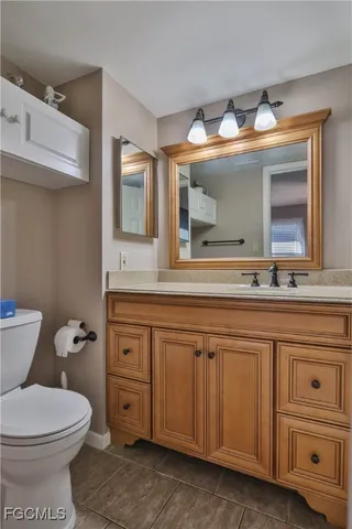 a bathroom with a toilet sink and mirror