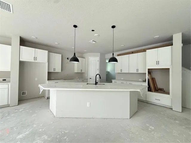 a large white kitchen with cabinets and a sink