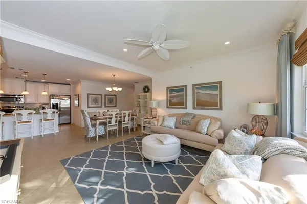 a living room with furniture a table and kitchen view