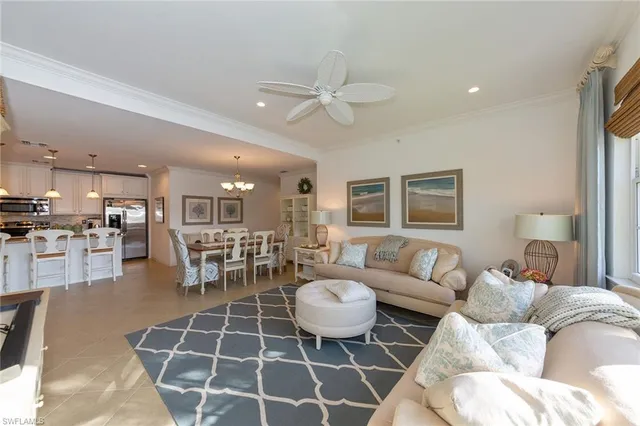 a living room with furniture a table and kitchen view