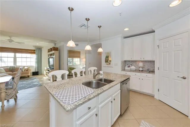 a kitchen with center island a sink stainless steel appliances and living room view
