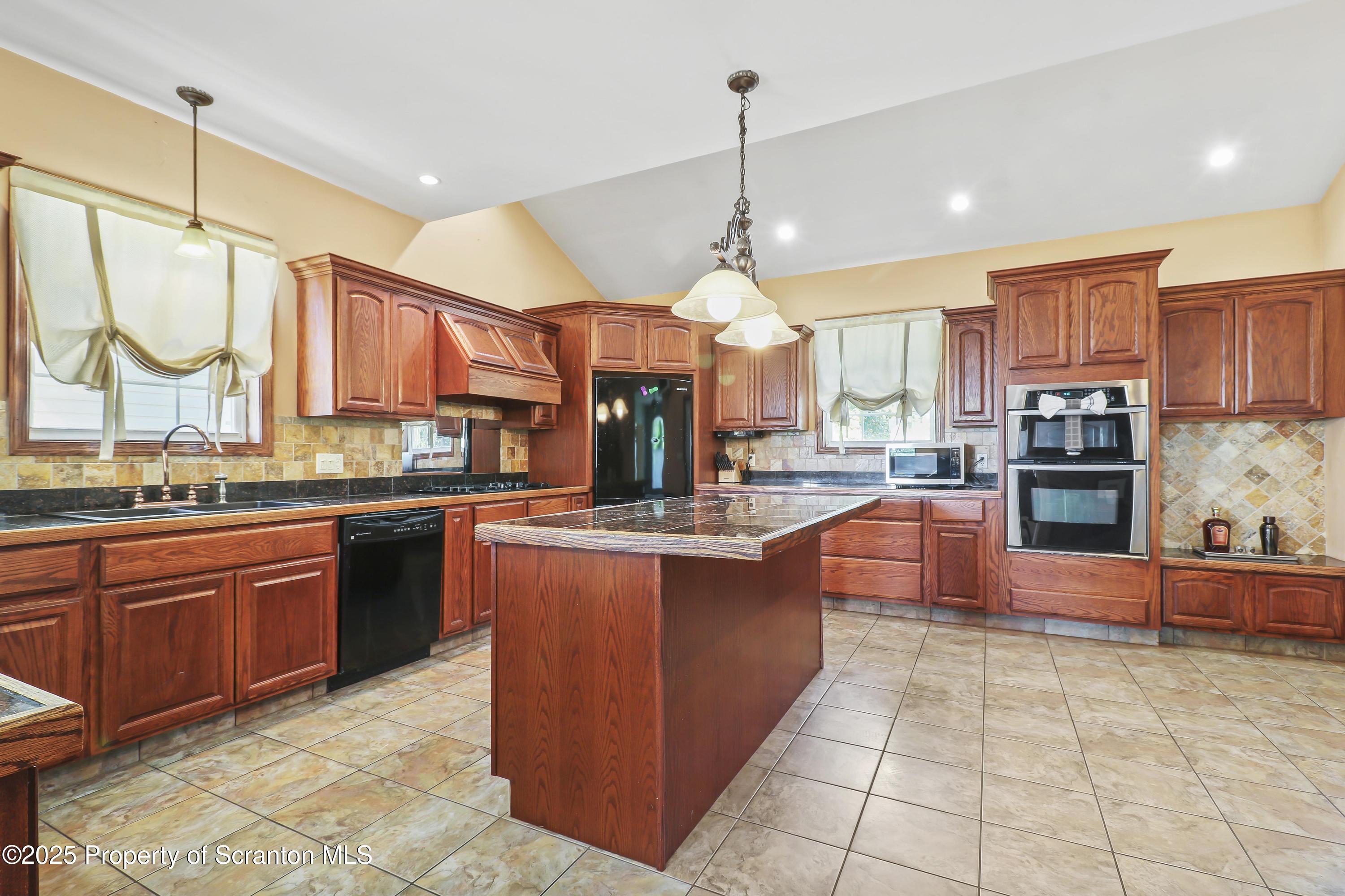 107 Ridgeview Drive Scranton, PA 18504 - Photo 16 of 48 a large kitchen with stainless steel appliances granite countertop a stove and a view of living room