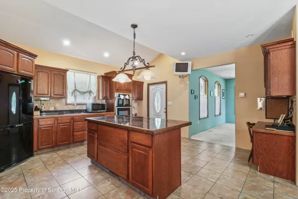 a kitchen with stainless steel appliances granite countertop counter top space a refrigerator a sink and cabinets