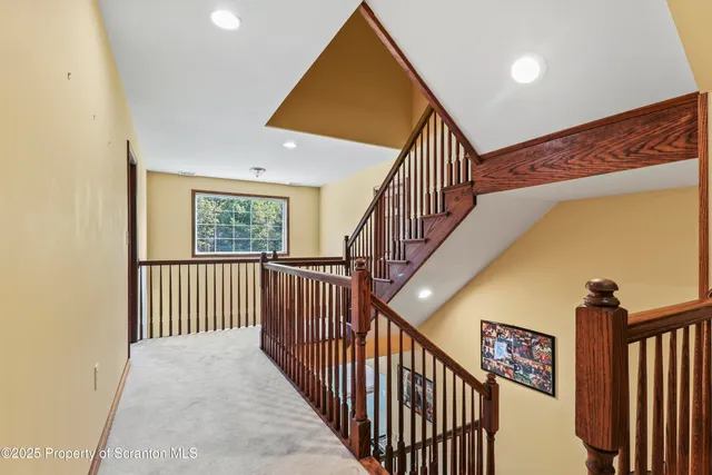 a view of staircase with railing and a window