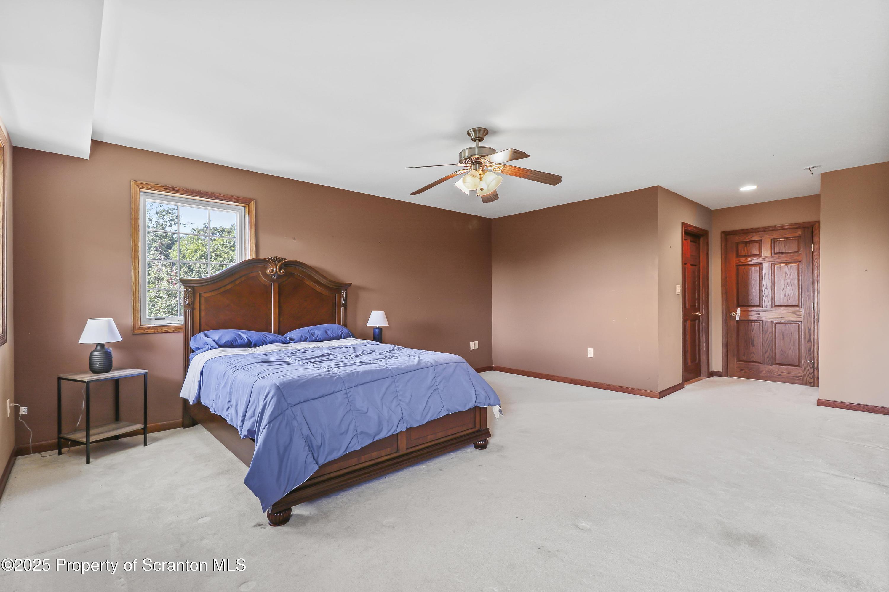 107 Ridgeview Drive Scranton, PA 18504 - Photo 26 of 48 a bedroom with a bed and a chandelier