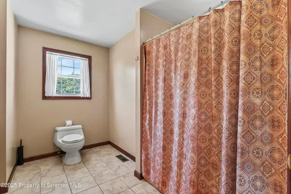 a bathroom with a toilet and a shower curtain
