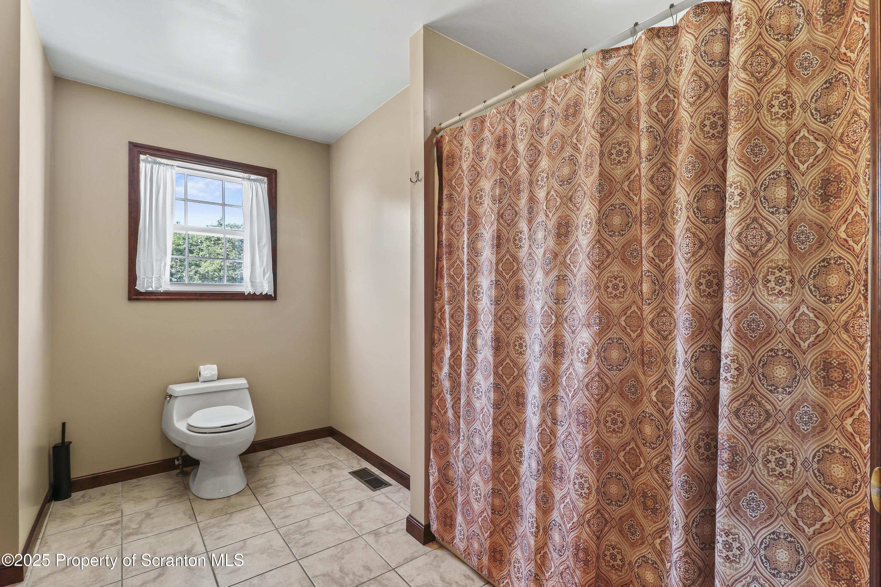 107 Ridgeview Drive Scranton, PA 18504 - Photo 28 of 48 a bathroom with a toilet and a shower curtain