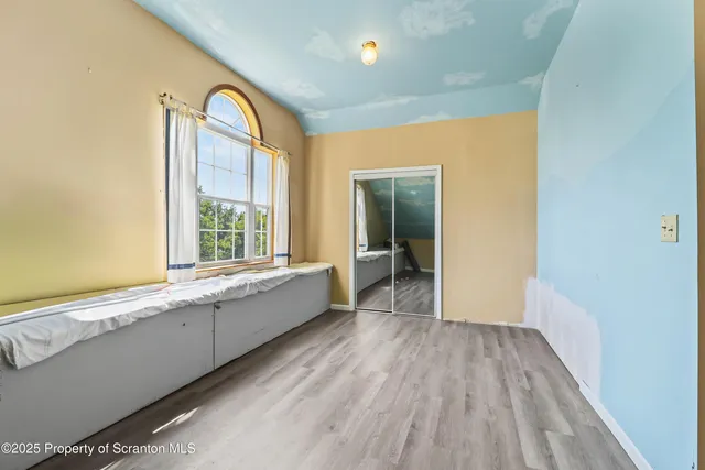 an empty room that has a window and kitchen view
