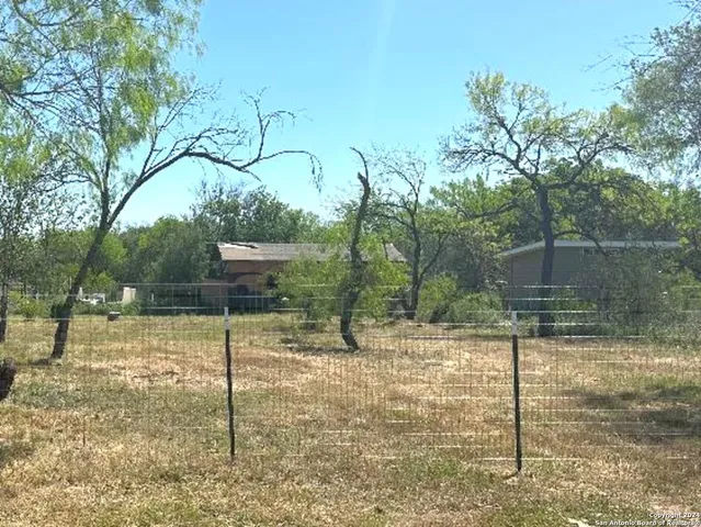 a backyard of a house with lots of tall trees