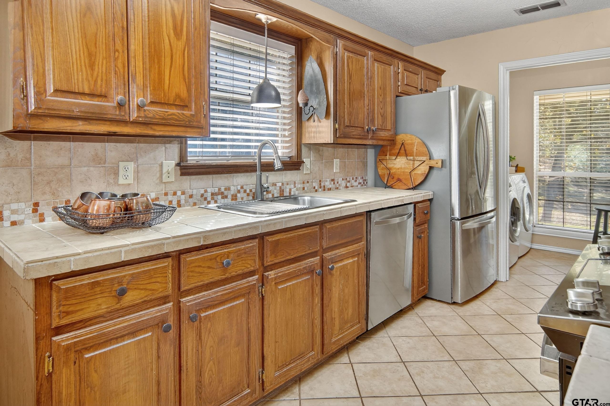 810 Jeanell Street Quitman, TX 75783 - Photo 14 of 37 a kitchen with stainless steel appliances granite countertop a sink and a refrigerator