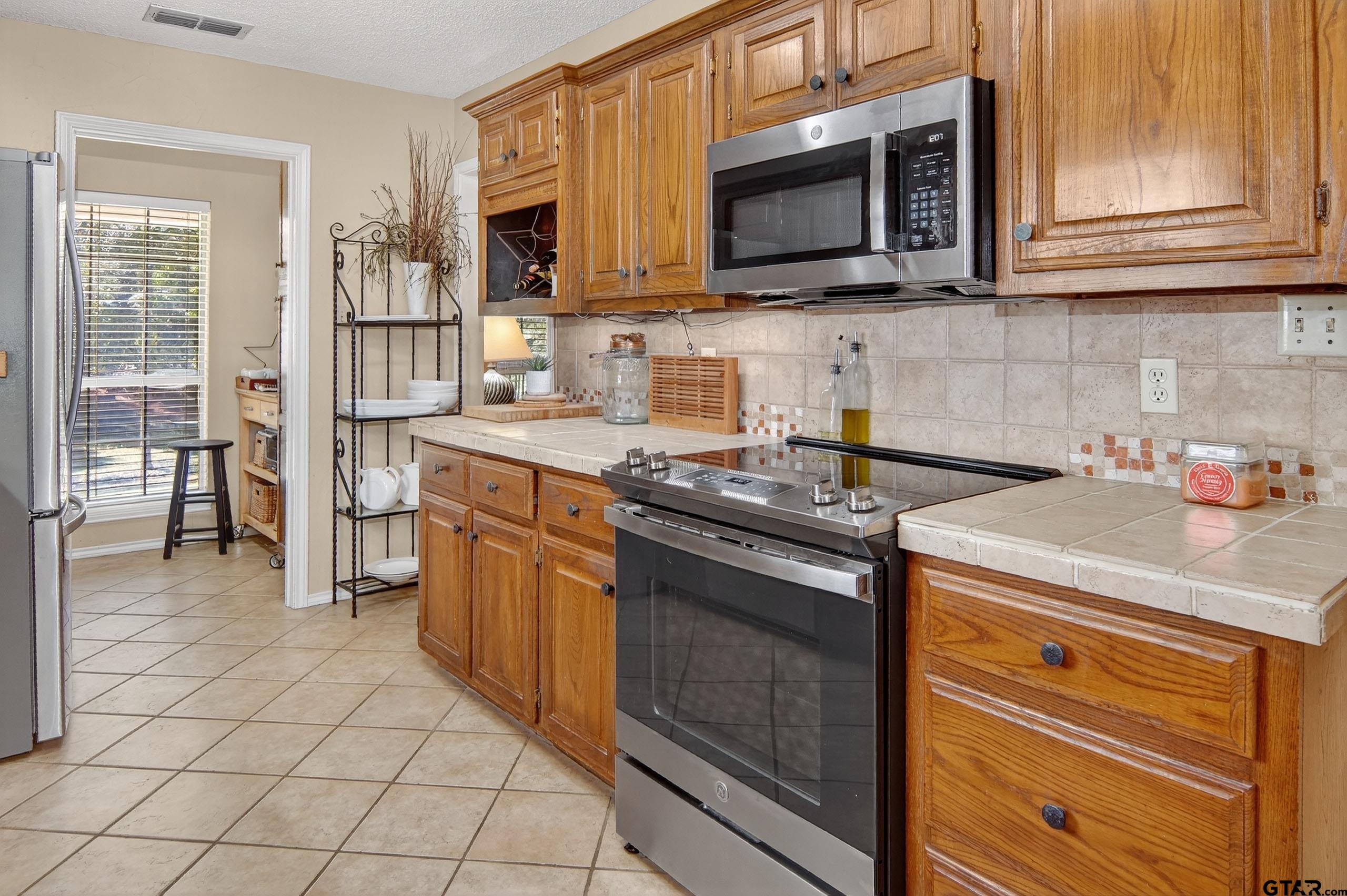 810 Jeanell Street Quitman, TX 75783 - Photo 15 of 37 a kitchen with stainless steel appliances granite countertop a stove microwave and cabinets