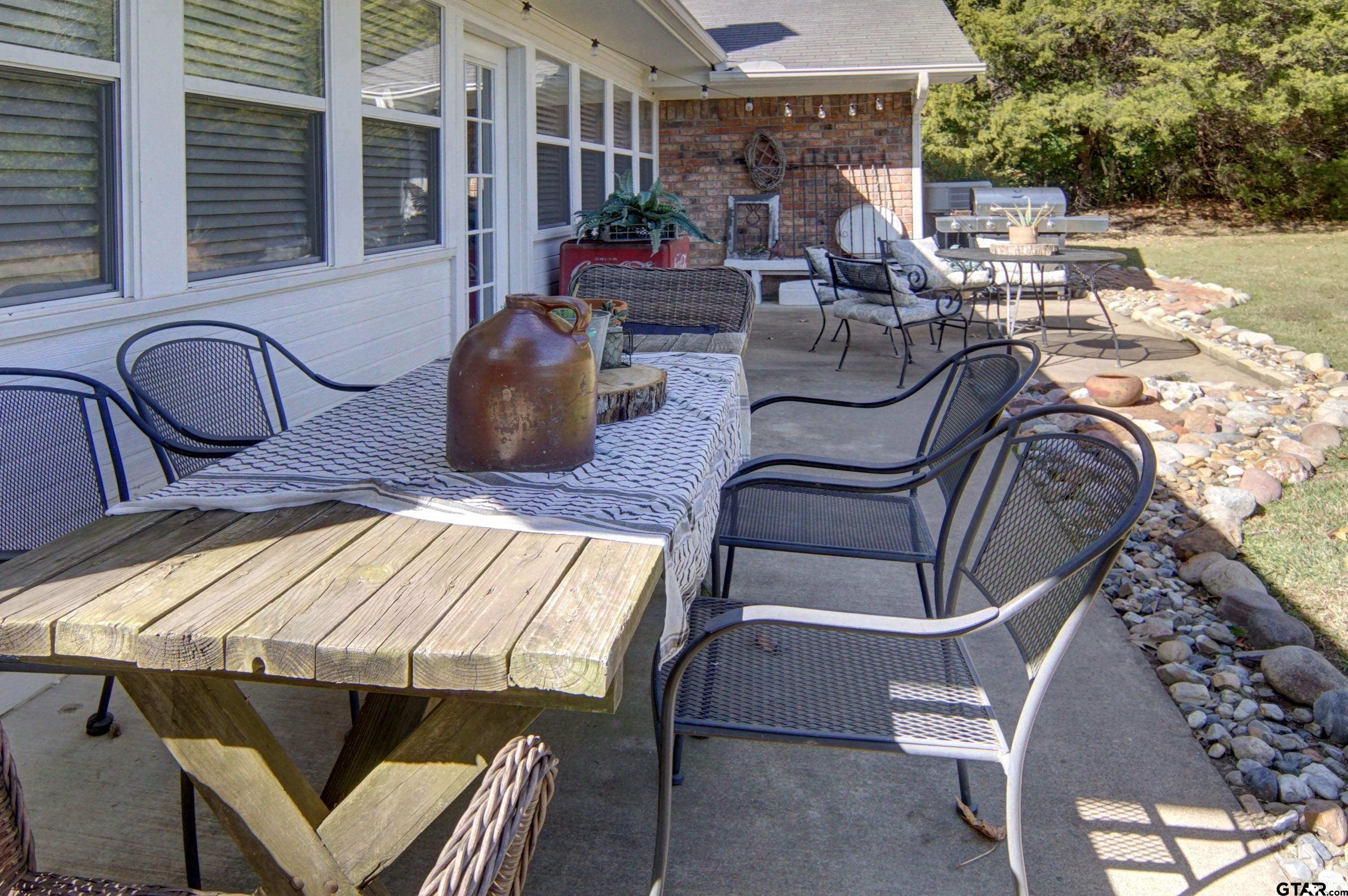 810 Jeanell Street Quitman, TX 75783 - Photo 32 of 37 a view of a patio with table and chairs potted plants with wooden floor and fence