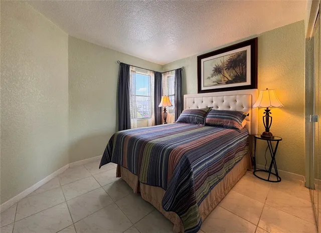 a bedroom with a bed and a painting on the wall