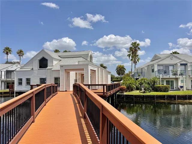 a view of a house with swimming pool and a wooden deck