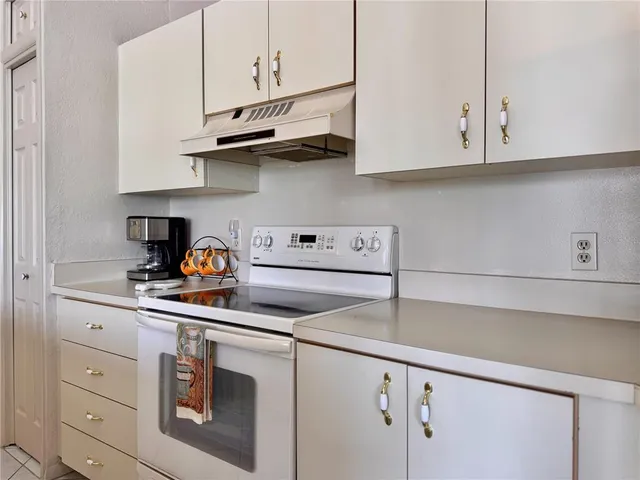 a kitchen with stainless steel appliances granite countertop white cabinets and a stove