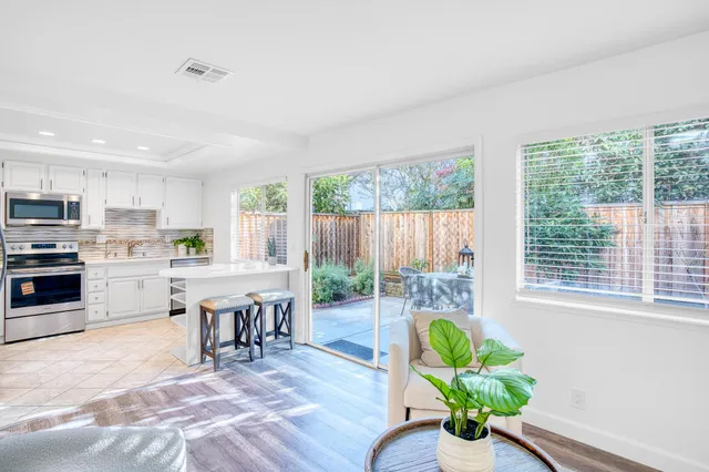 a living room with stainless steel appliances furniture and a large window