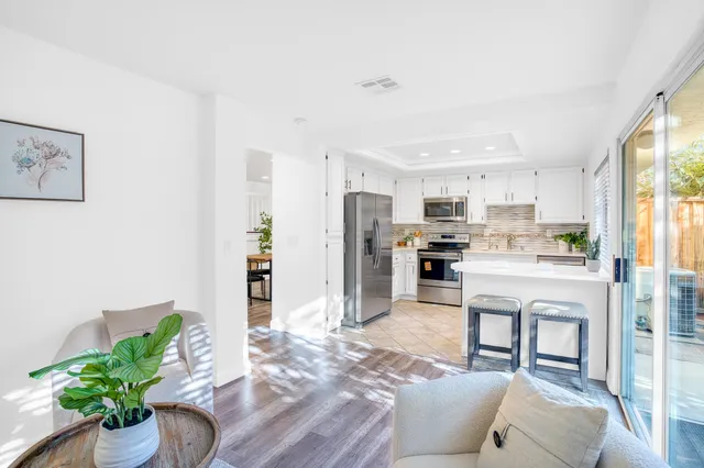 a living room with kitchen island furniture and a potted plant