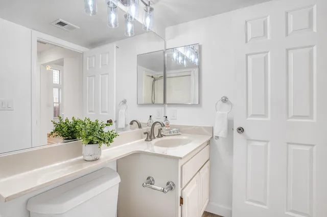 a bathroom with a sink a toilet and a mirror