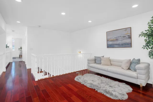 a living room with furniture and a wooden floor