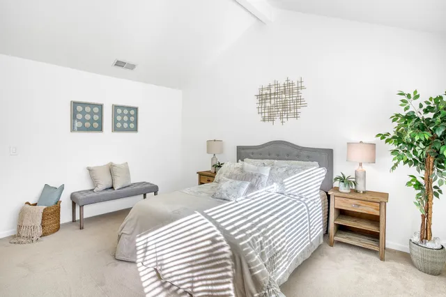 a bedroom with bed and a potted plant