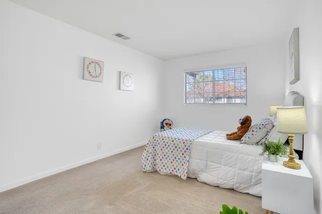 a bedroom with a bed and a lamp on the dresser