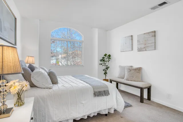 a bedroom with a bed and a painting on the wall