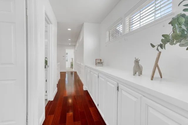a view of a hallway with a sink and wooden floor