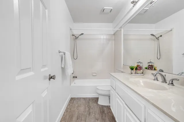 a bathroom with a granite countertop sink a toilet and shower