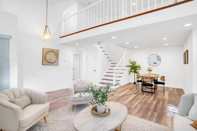a living room with furniture kitchen view and a potted plant