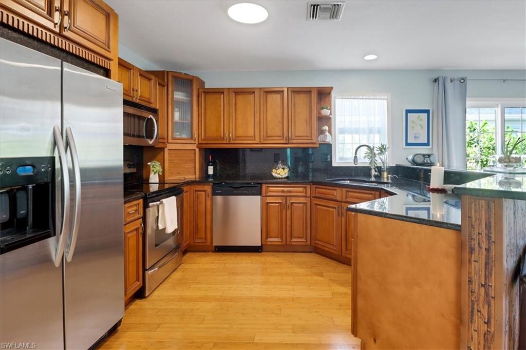 370 Leawood Circle Naples, FL 34104 - Photo 12 of 31 a kitchen with granite countertop a sink stainless steel appliances and cabinets