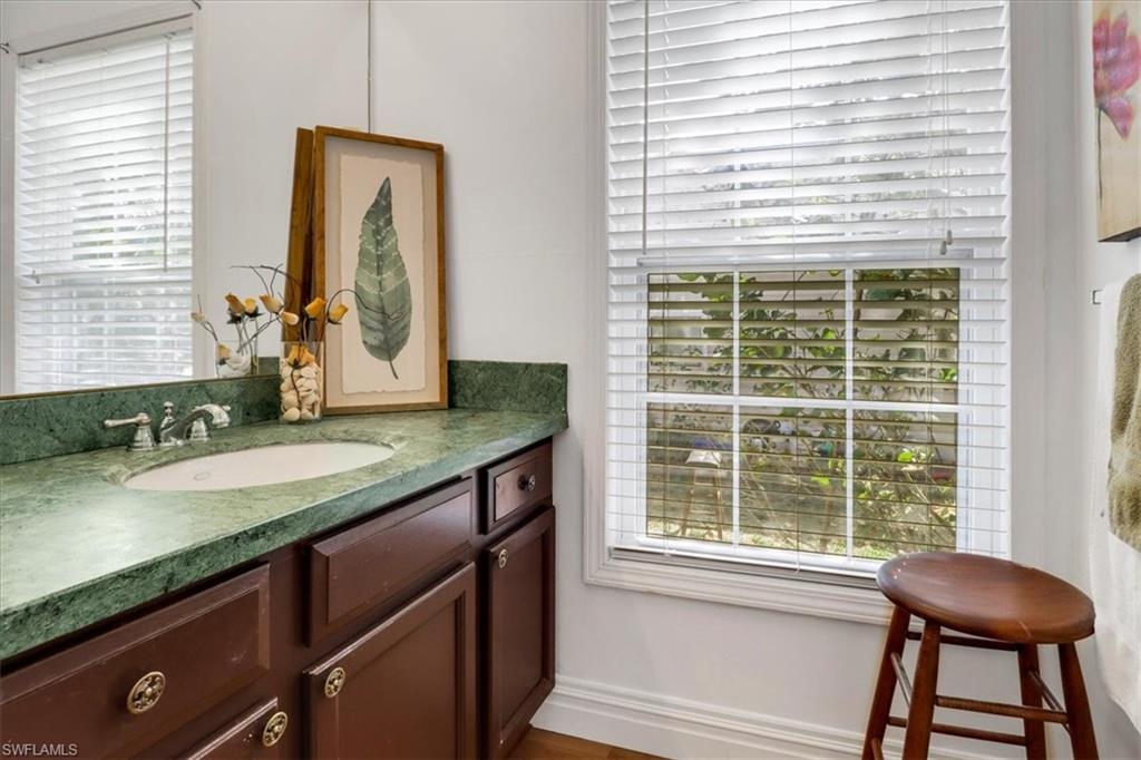 370 Leawood Circle Naples, FL 34104 - Photo 18 of 31 a bathroom with a granite countertop sink and a mirror