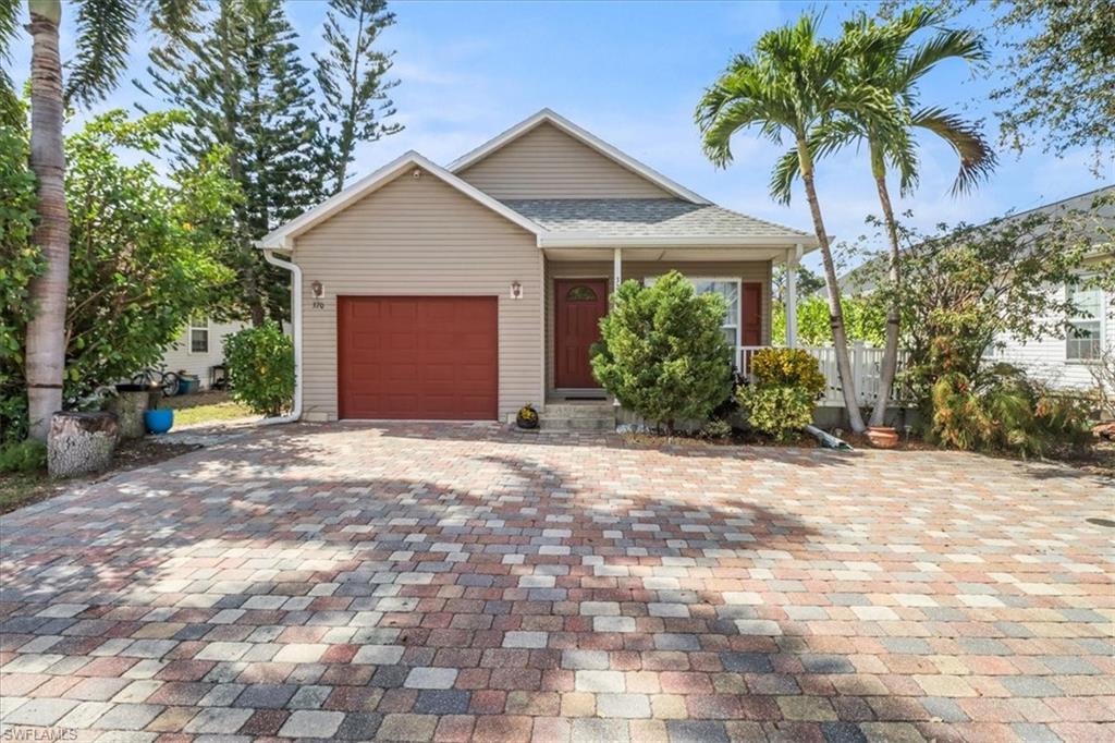 370 Leawood Circle Naples, FL 34104 - Photo 2 of 31 a front view of a house with a yard and garage