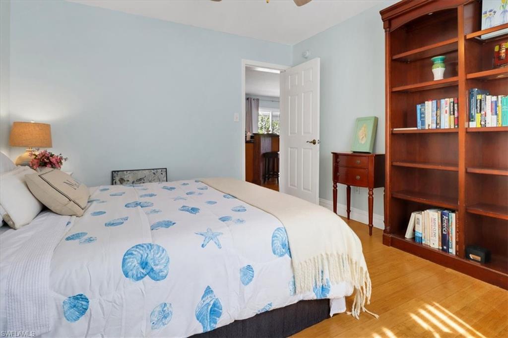 370 Leawood Circle Naples, FL 34104 - Photo 21 of 31 a bedroom with a bed and a book shelf